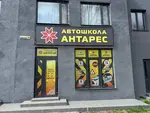 Сучасний фасад та вхід до автошколи «Антарес» у Ладижині за адресою вул. Будівельників, 38Г. На вітринах розміщена інформація про категорії навчання та графік роботи.
